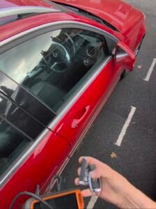 Steering lock emulator for a 2013 Mercedes C-Class held beside the car