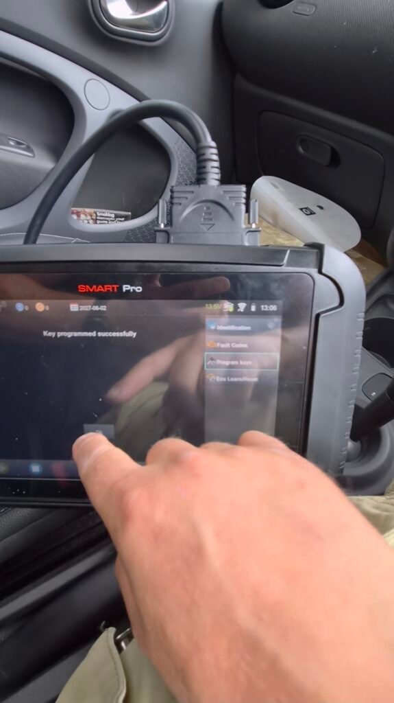 Key programmer in use inside a 2017 Smart ForTwo during spare key programming