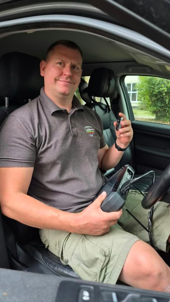 Darius Arbaciauskas, auto locksmith at Herts Car Keys, holding a car key and a key programmer